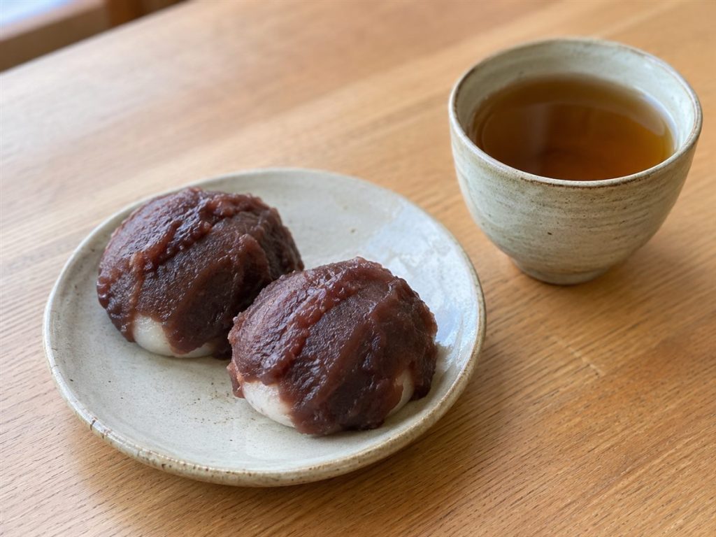あんをのせた二つの餅とほうじ茶