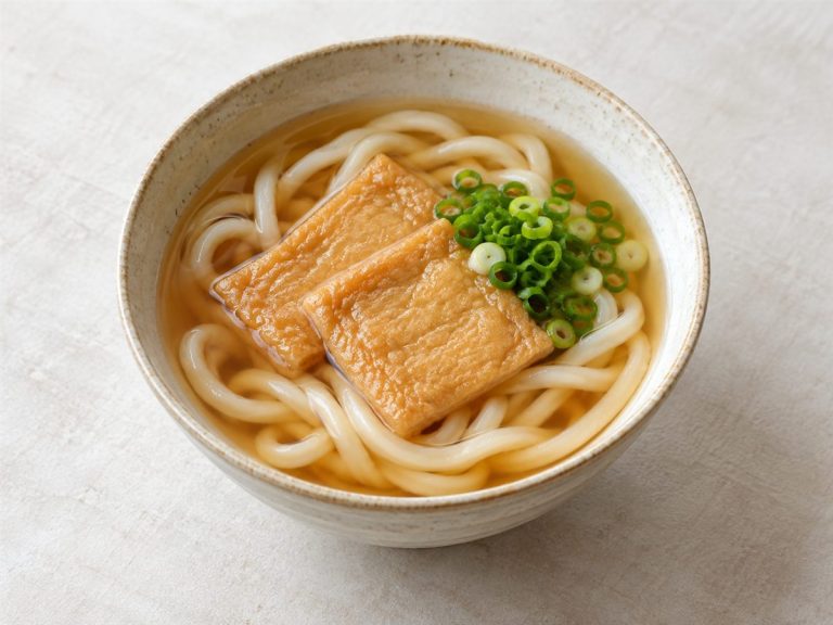 つゆに太いうどん、油揚げとねぎを合わせた一杯
