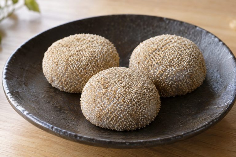 皿に並べた、淡い茶色のけし実で覆われた丸いけし餅の生成イメージ