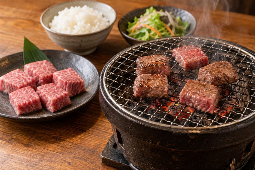 卓上の網で焼く牛肉と、別皿の霜降り肉、ご飯、サラダ