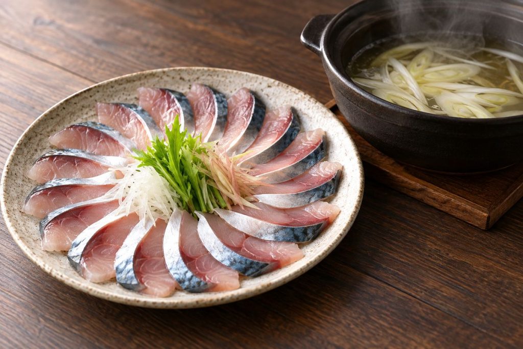 薄切りのさばを皿に並べ、玉ねぎ入りの鍋を添えた生成イメージ